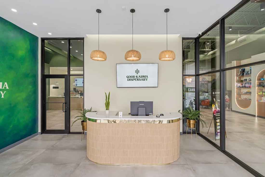 Reception desk with computer and hanging lights in a modern lobby area